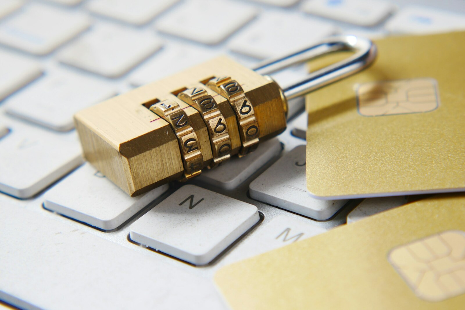 A padlock and a credit card resting on a keyboard