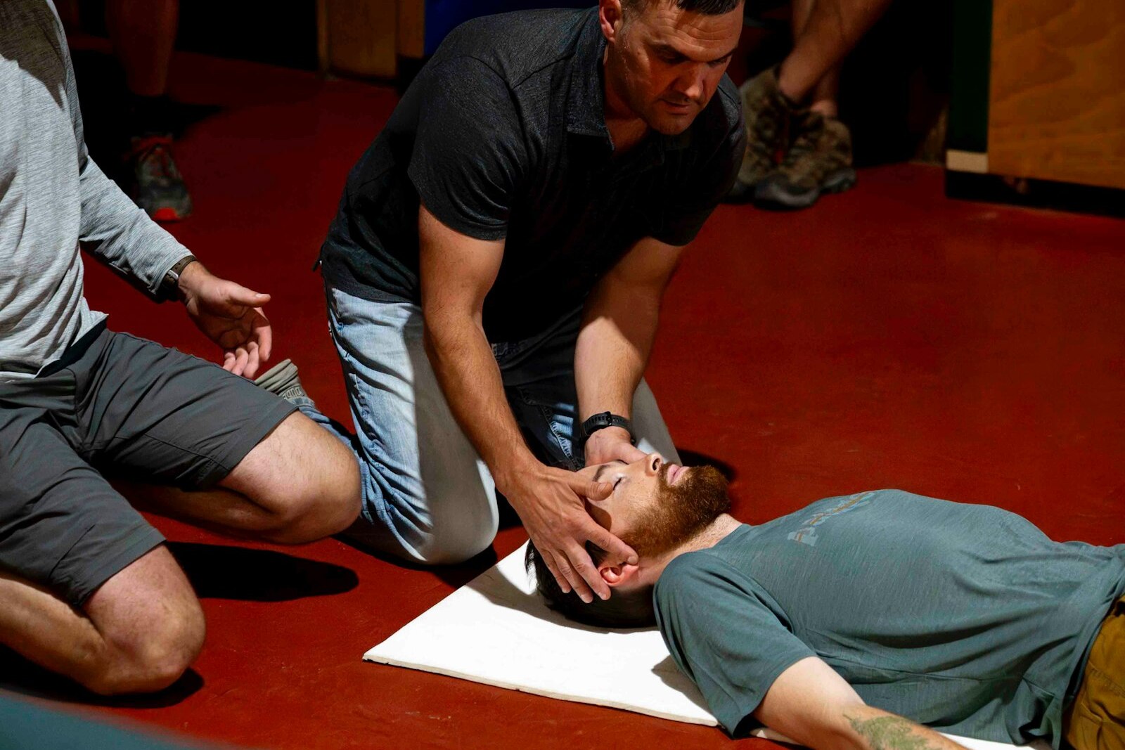 An instructor practicing an airway check with a participant during a hands-on first aid drill