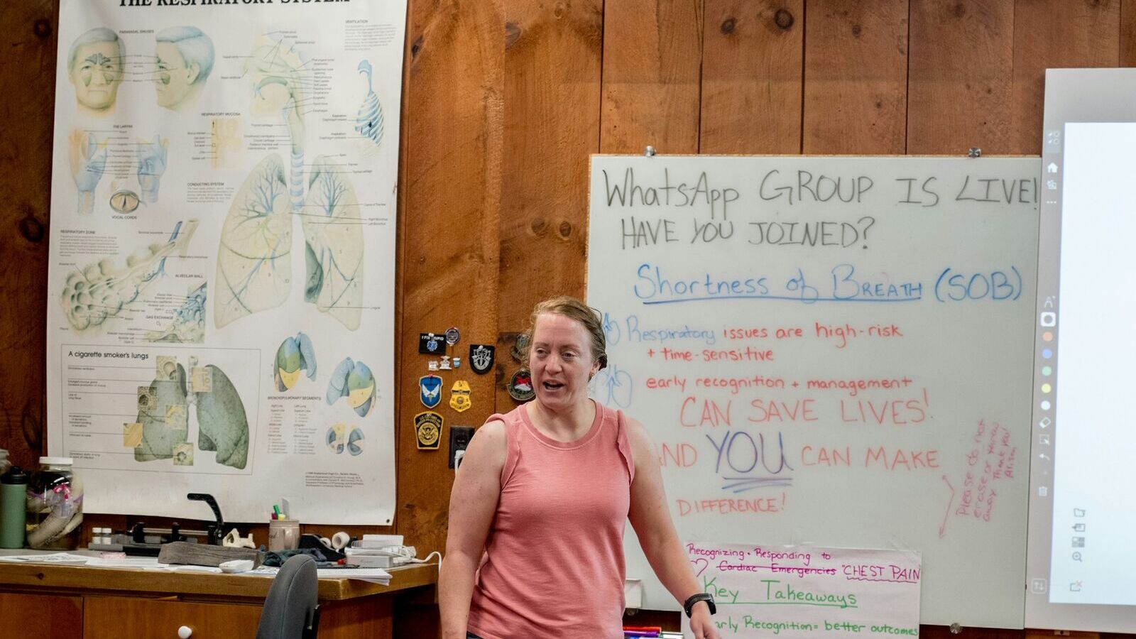 A teacher explaining a lesson at the whiteboard, in front of the class