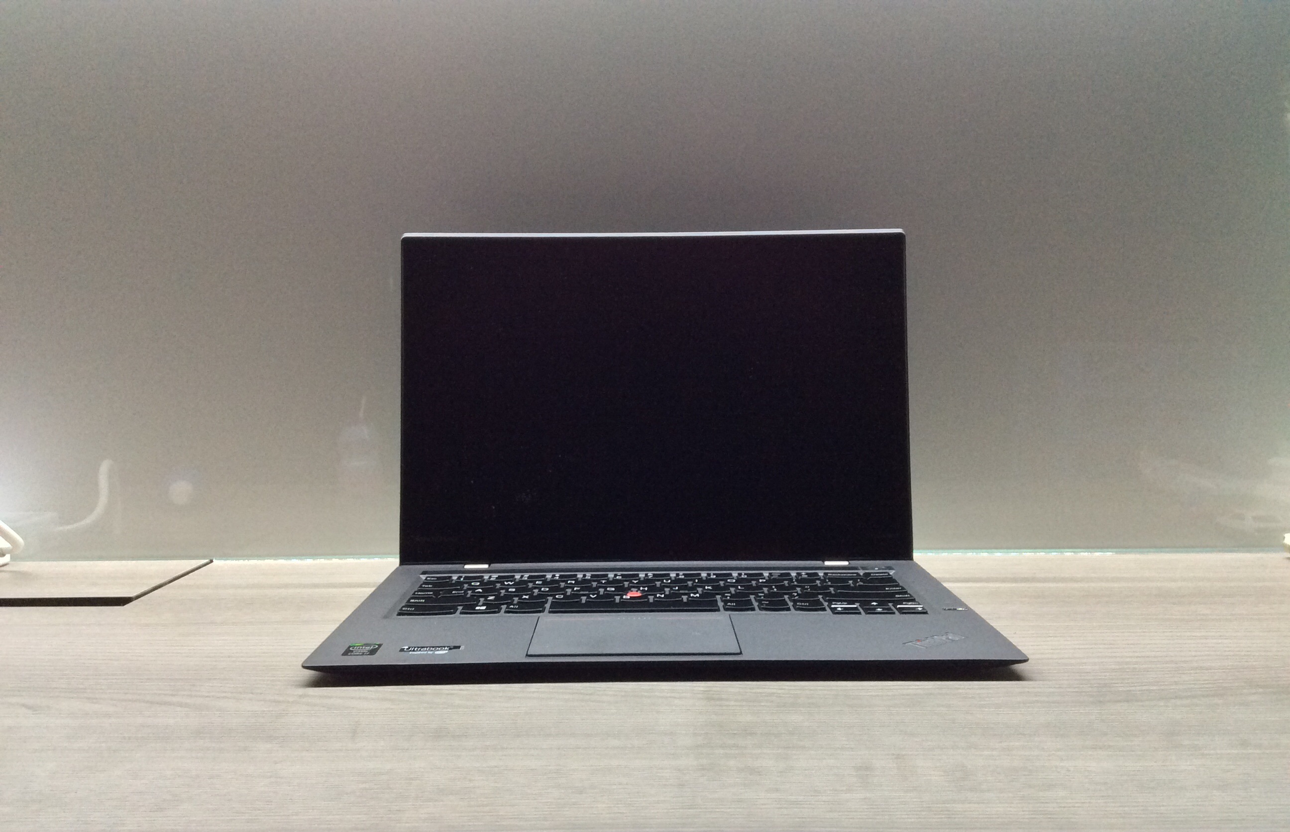 A Lenovo ThinkPad X1 Carbon laptop, closed lid facing forward, on a desk